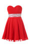Petite robe rouge ornée de paillettes au niveau de la taille