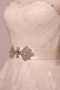 Robe longue de mariée en tulle bustier sans bretelle ornée de bijoux